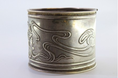 Argola de guardanapo em prata com laços e fitas relevadas em bustos de damas.